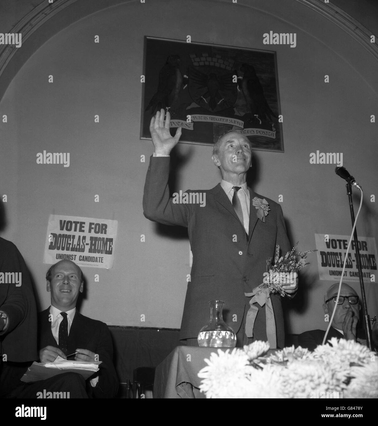 Prime Minister Sir Alec Douglas-Home holds a lucky white heather, the gift of a well-wisher, as he waves to the crowd at Auchterarder in Scotland. He is contesting the Kinross and West Perthshire by-election as a Conservative candidate. Stock Photo