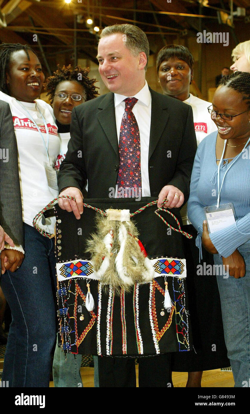 Scottish First Minister Jack McConnell is given a Kilt made by the pupils of Zwelibanzi High school in Durban by african guests of the Scottish Executive. The SNP today attempted to embroil First Minister Jack McConnell in the political storm over the legality of the war with Iraq. SNP Holyrood leader Nicola Sturgeon accused him of misleading the Scottish Parliament, 'albeit inadvertently', over the legal justification for going to war. Stock Photo