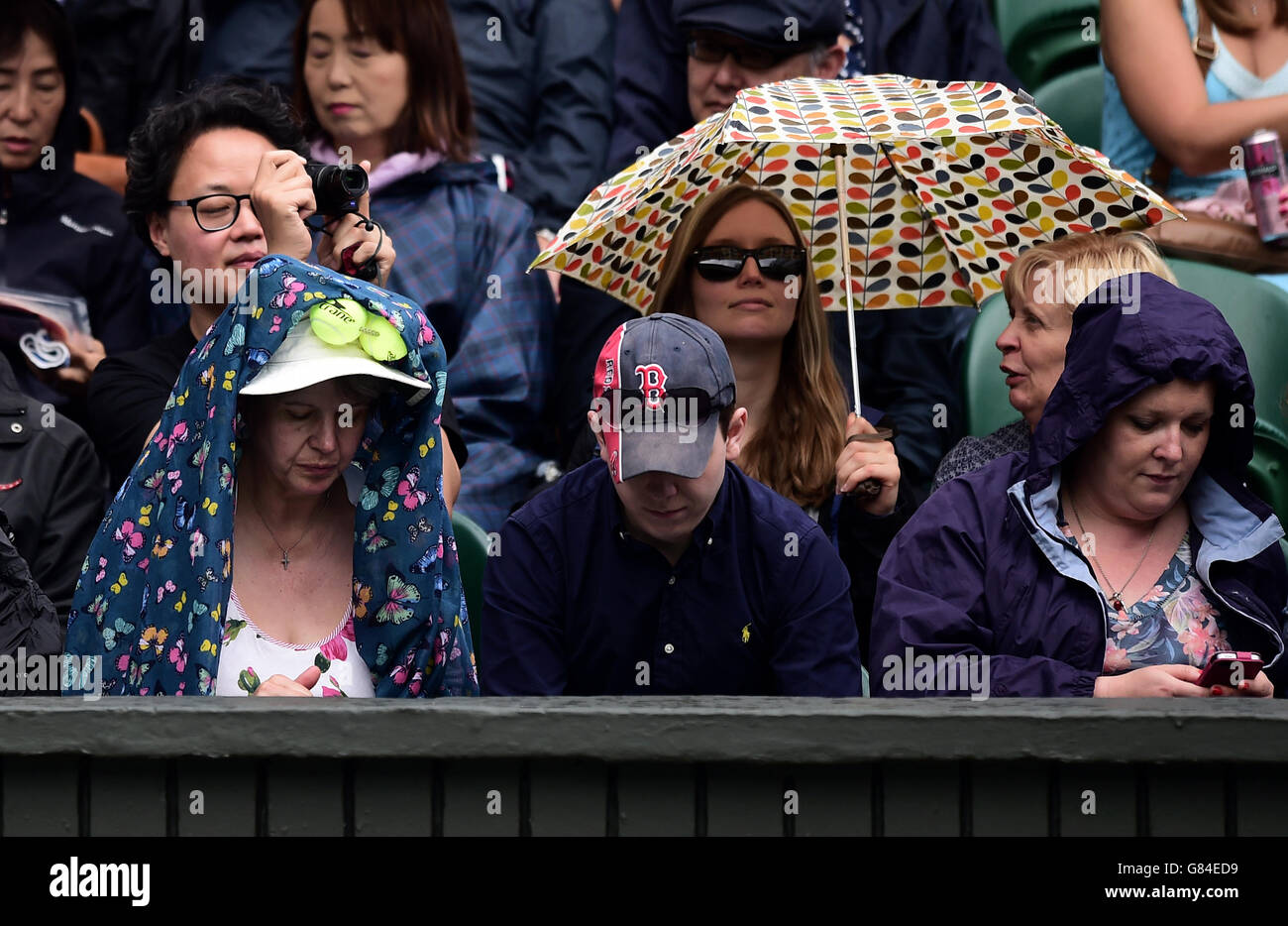 Umbrellas go up on centre court as rain delays play during day Eight of the Wimbledon Championships at the All England Lawn Tennis and Croquet Club, Wimbledon. Stock Photo