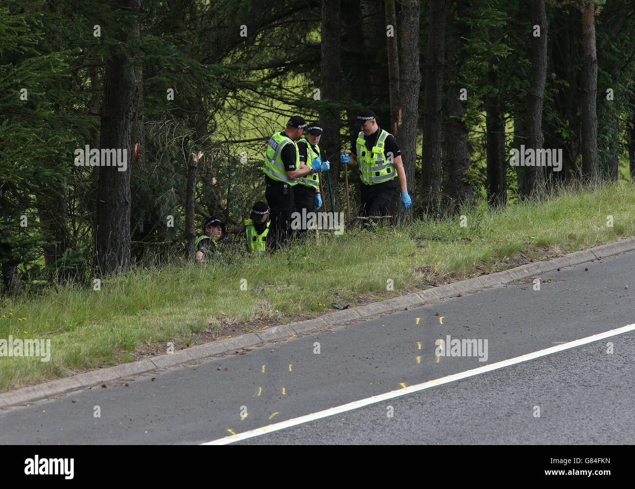 Police officers search the scene at Junction 9 of the M9 after a car was discovered yesterday off the road with the driver dead and passenger still alive. An investigation has been launched into the police failure to follow up a report of the crash which killed John Yuill, 28, and left 25-year-old Lamara Bell critically injured in hospital. Stock Photo