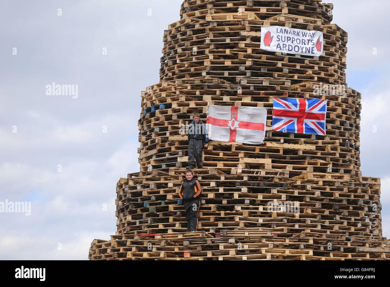 Bonfire builders in the New Mosley area of Belfast, hundreds of fires will be set alight at midnight, on the July 11, as loyalists celebrate the July 12, remembering the defeat of the catholic King James, by the Protestant William of Orange in 1690. Stock Photo
