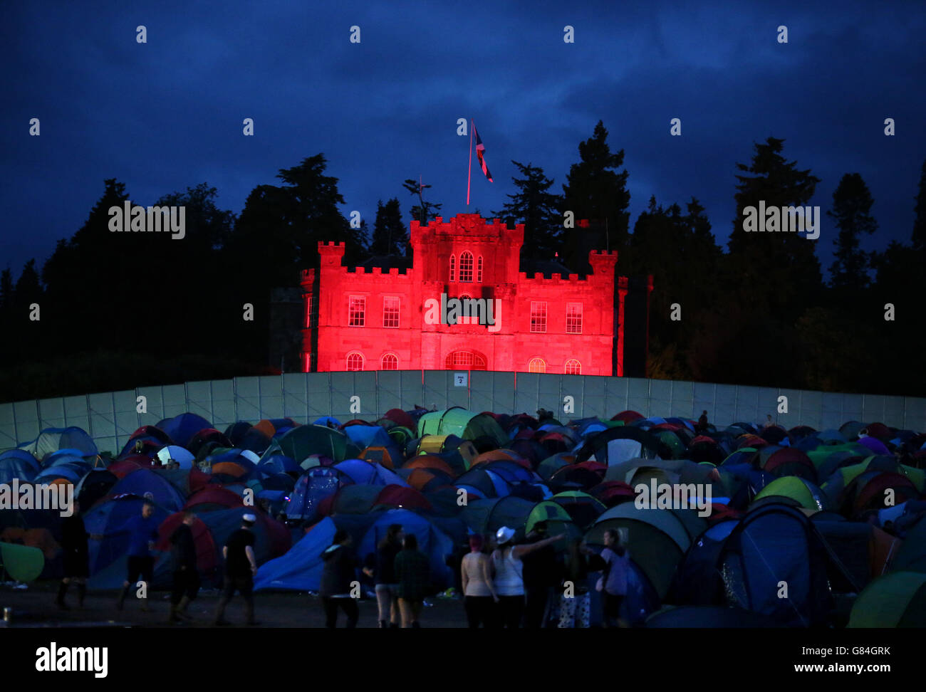 Strathallan Castle is floodlit red as it overlooks the campsite at the T in the Park music