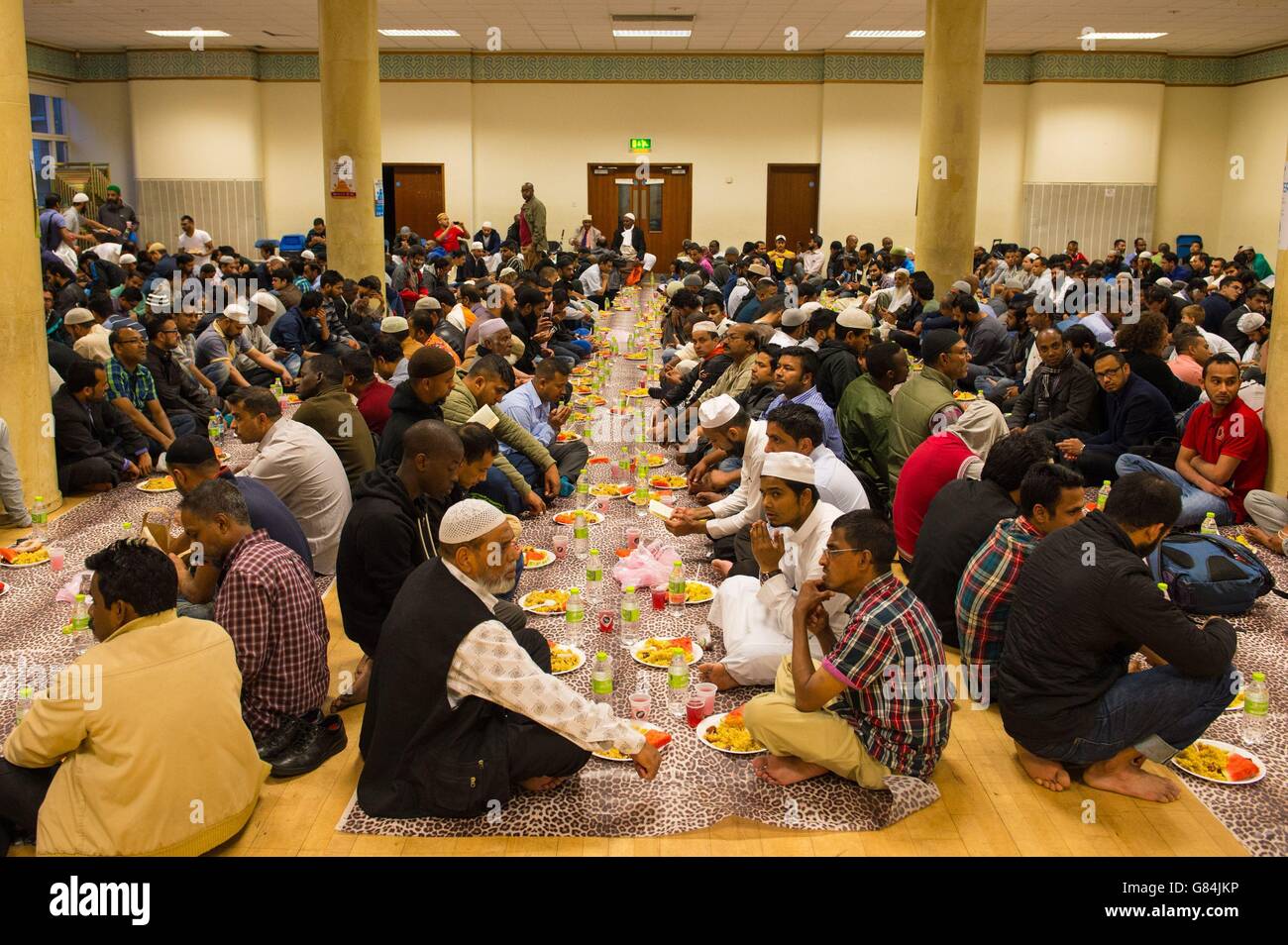 Muslim men prepare to eat Iftar, the evening meal to break fast during Ramadan, at the East London Mosque, in Whitechapel, London. Stock Photo