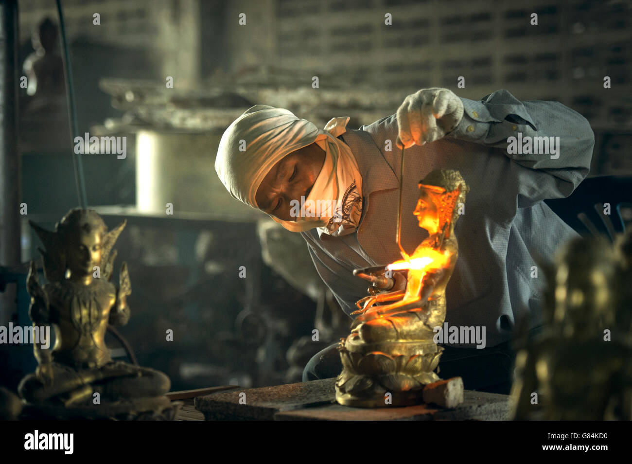 Man welding a traditional buddha sculpture, Thailand Stock Photo