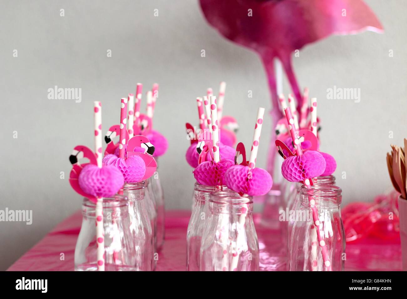 Pink flamingo straws in glass bottles in a row Stock Photo