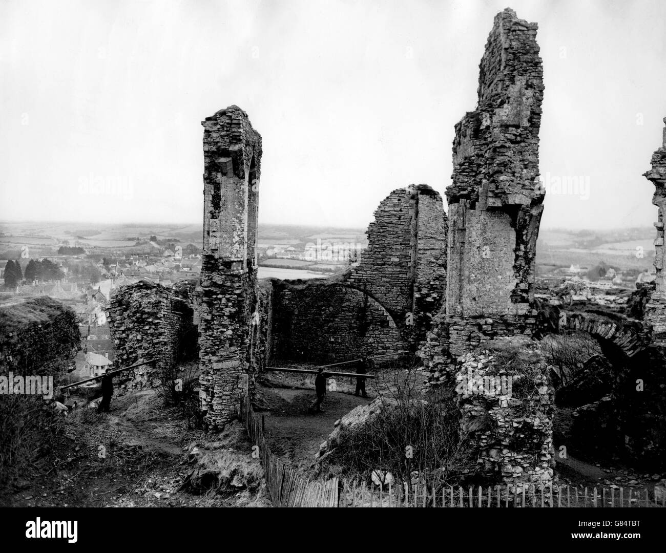Buildings and Landmarks - Corfe Castle - Dorset - 1959. The ruins of Corfe Castle dominate the countryside. Men carry in equipment for repairs to the castle. Stock Photo
