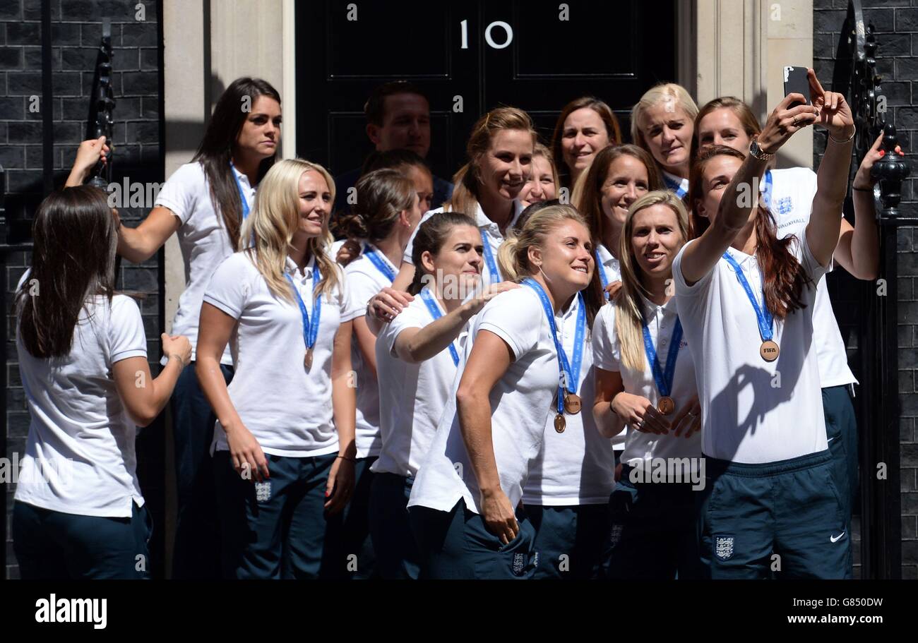 Members of England Women's Football team stand on the steps of 10