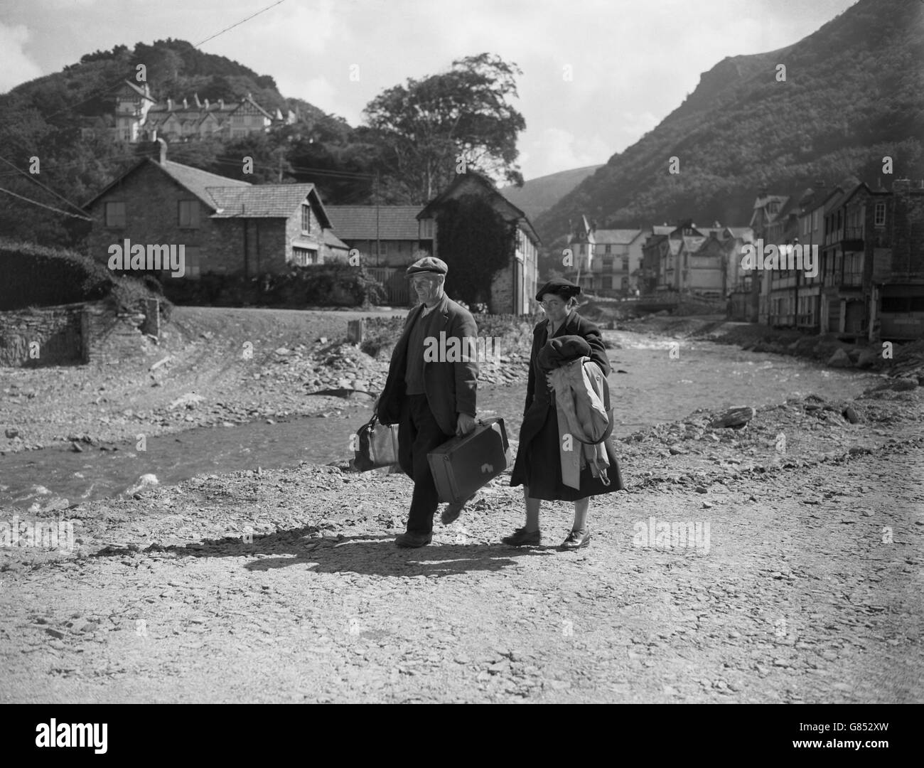 Mr and Mrs A Palmer walk to their cottage on Mars Hill on the day the flood-damaged town of Lynmouth re-opened to visitors. Stock Photo
