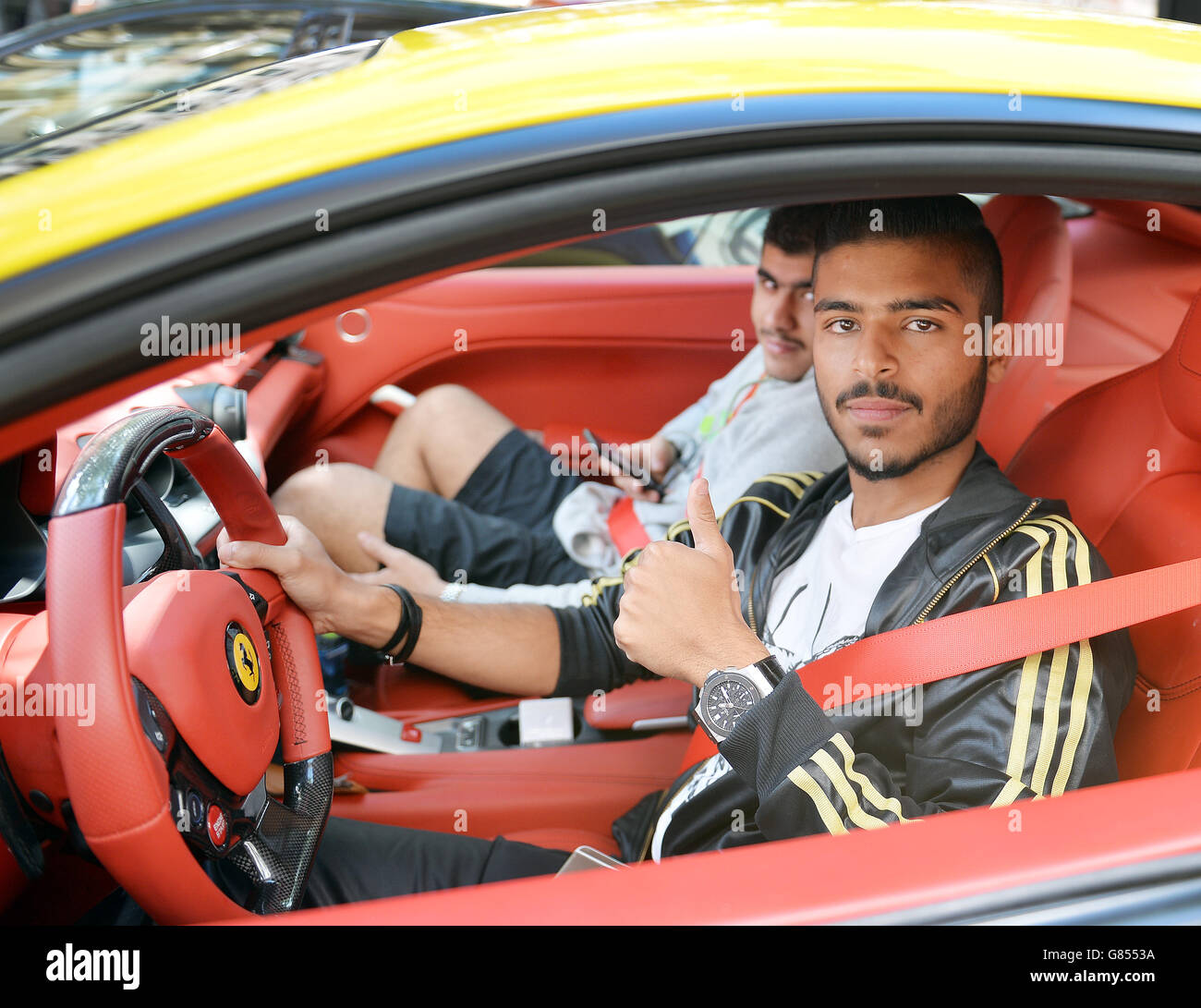 Fahad from Saudi Arabia, sits in his parked black and yellow Ferrari close to Harrods department store in Knightsbridge central London. Stock Photo