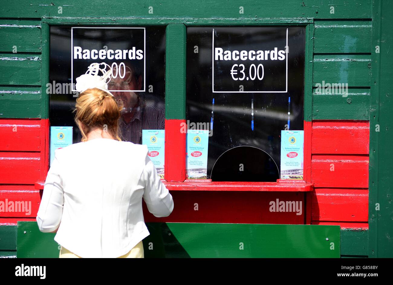 Racegoer Teresa Flannery from Co Mayo buys a racecard during day two of the Galway Festival at Galway Racecourse, Ballybrit. Stock Photo