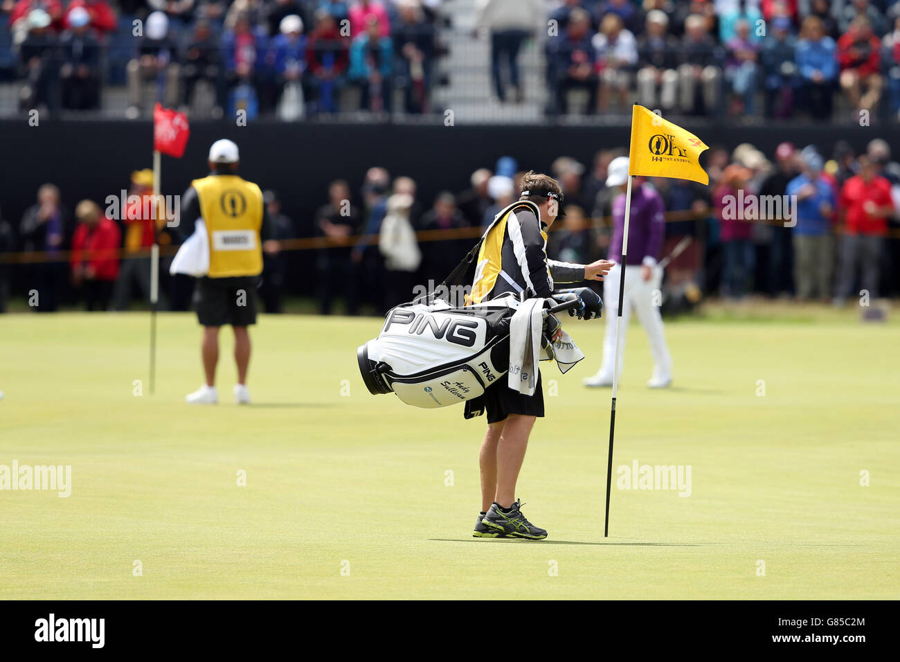 The caddie of England's Andy Sullivan takes out a flag as his player