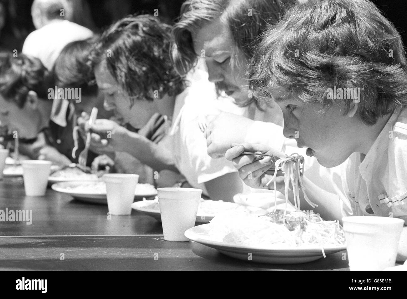 Competitors in a spaghetti-eating contest during the Soho Festival in London. Stock Photo