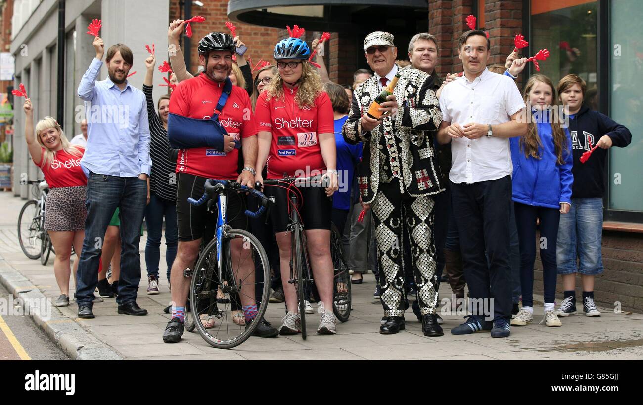 Fourteen-year-old Grace Stewart-Piercy (centre), along with her father Simon (second left), are greeted by John Walters (centre right) the Pearly King of Finsbury, and Campbell Robb (third right) Chief Executive of Shelter as well as other staff from Shelter as they arrive at the London offices of Shelter following their five hundred mile fundraising cycling trip from Edinburgh to London. Stock Photo