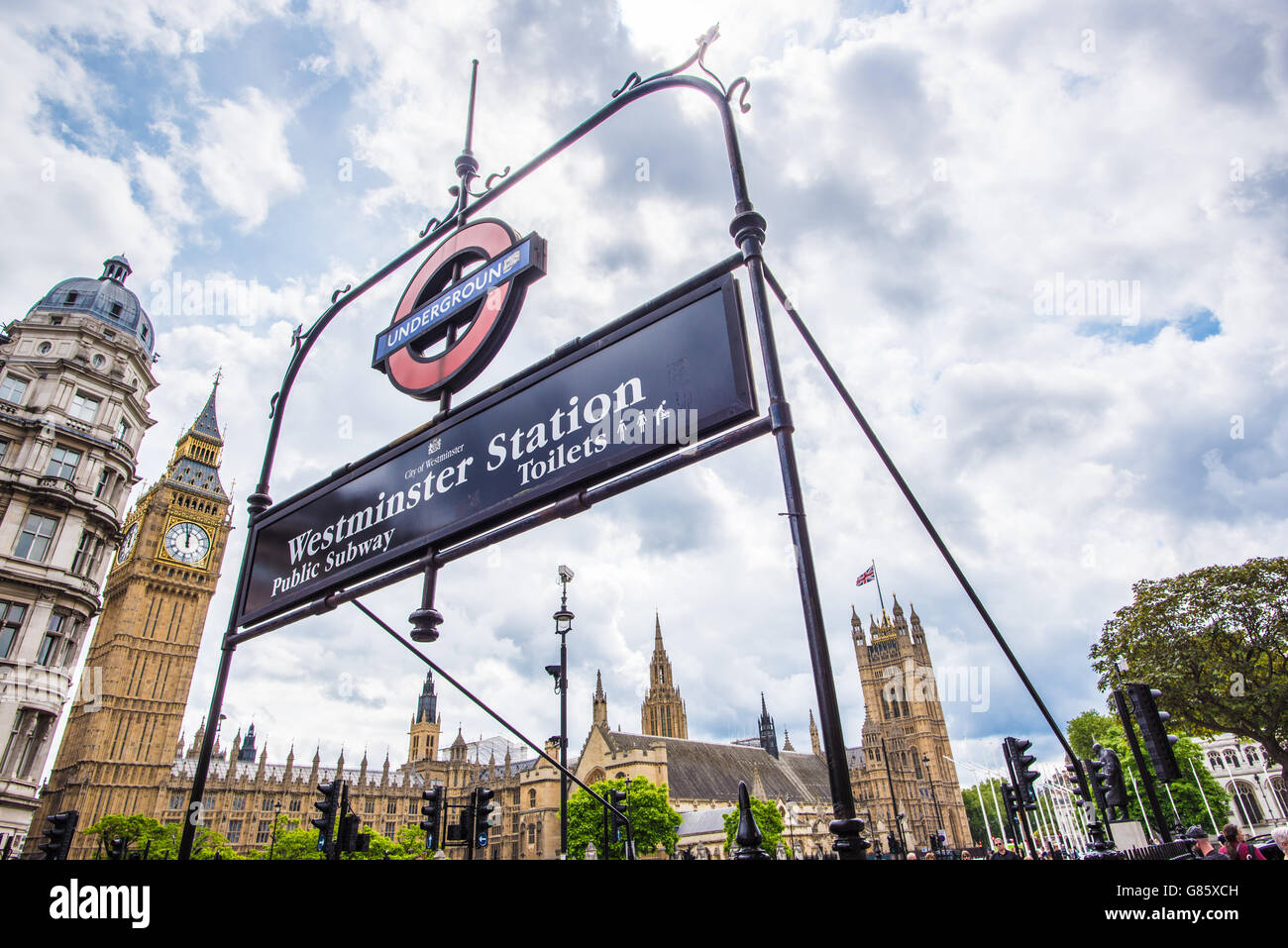 The Houses of Parliament in London seen through the Westminster Underground sign on a cloudy day Stock Photo