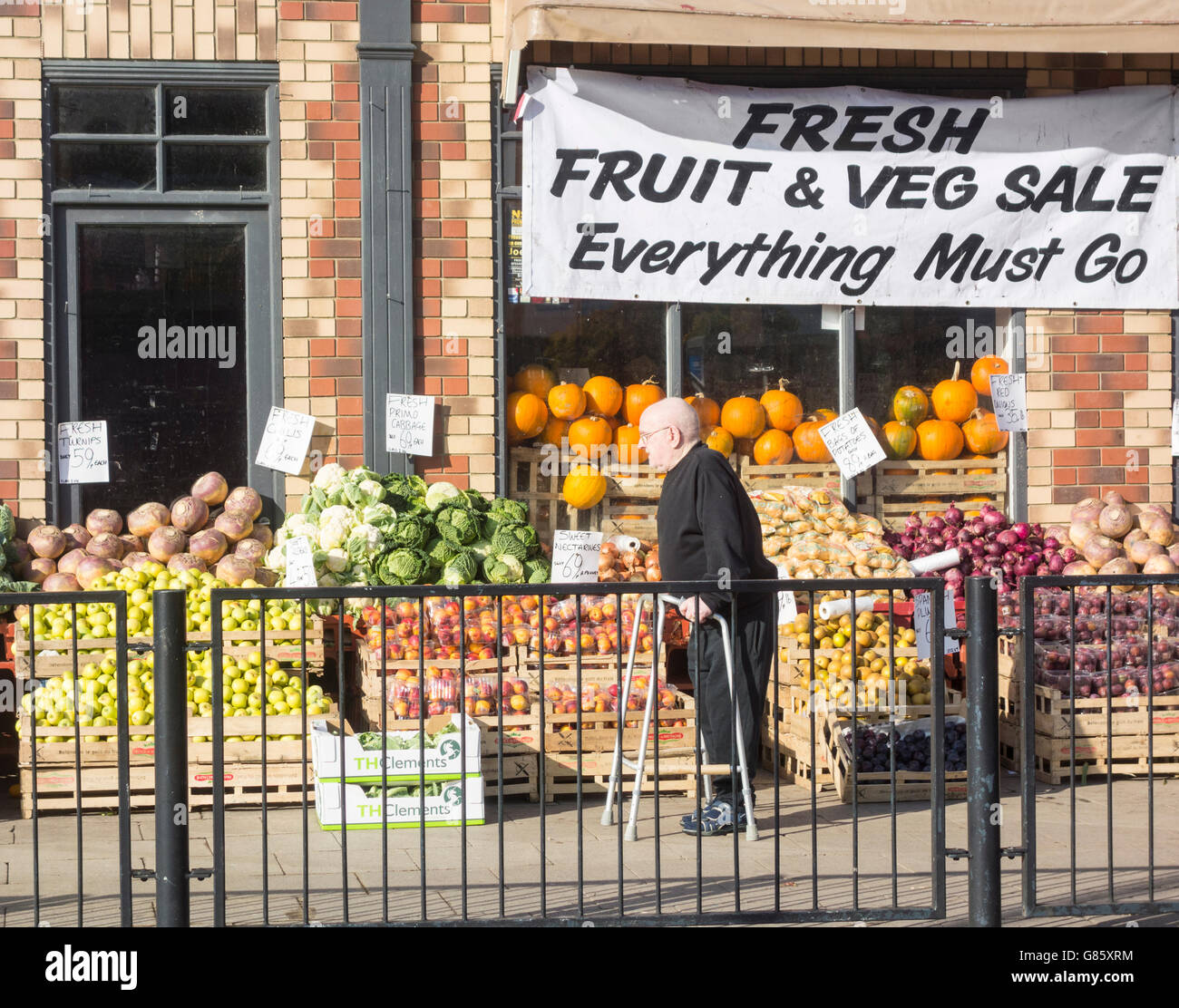 Elderly man with zimmer frame waling past fruit & veg shop on York Road, Hartlepool, north east England. UK Stock Photo