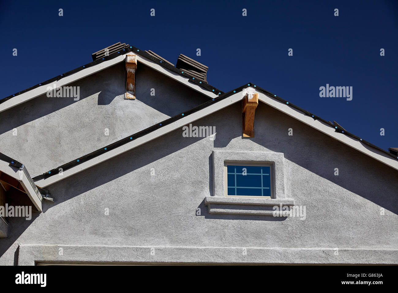 New Home Construction Double Gable Roof And Stucco Stock Photo