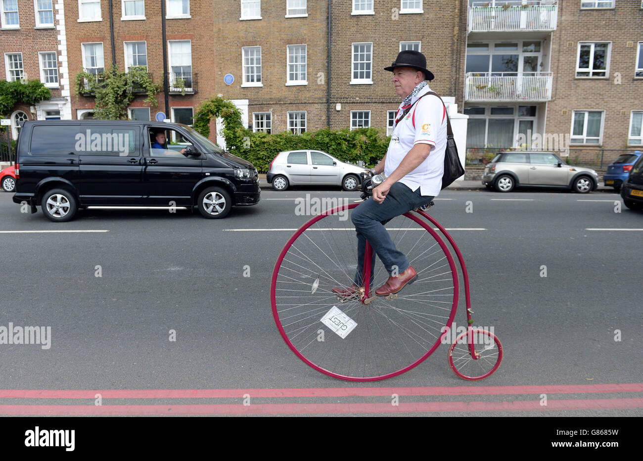 Alan Price cycles to work in London on a Penny farthing as commuters and tourists face a day of travel chaos because of a strike which has closed the underground Stock Photo