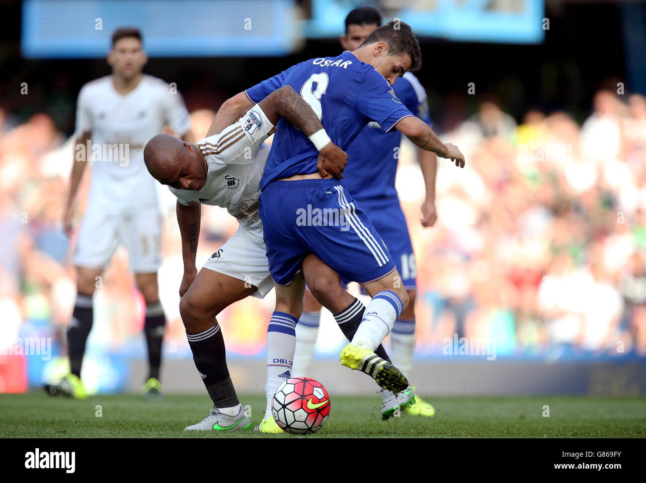 Swansea City's Andre Ayew (left) and Chelsea's Oscar battle for the ball during the Barclays Premier League match at Stamford Bridge, London. Stock Photo