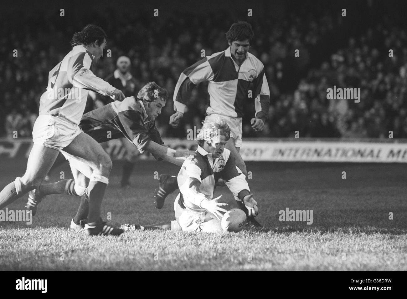 Steve Fenwick, captain of England/Wales, is tackled by John Robbie, of Scotland/Ireland, at Cardiff Arms Park. Also in the picture are Terry Holmes (l) and Gareth Williams. England/Wales won 37-33. Stock Photo