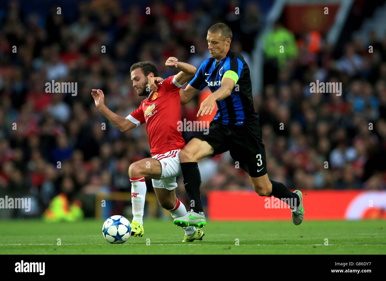 Club Brugge's Timmy Simons (right) and Manchester United's Juan Mata (left) battle for the ball during the UEFA Champions League Qualifying, Play-Off at Old Trafford, Manchester. Stock Photo