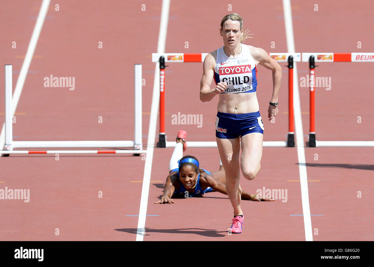 Great Britian's Eilidh Child sprints for the line as Italy's Yadisleidis Pedroso falls after hitting the final hurdle, in heat 2 of the Women's 400m Hurdles, during day two of the IAAF World Championships at the Beijing National Stadium, China. Stock Photo