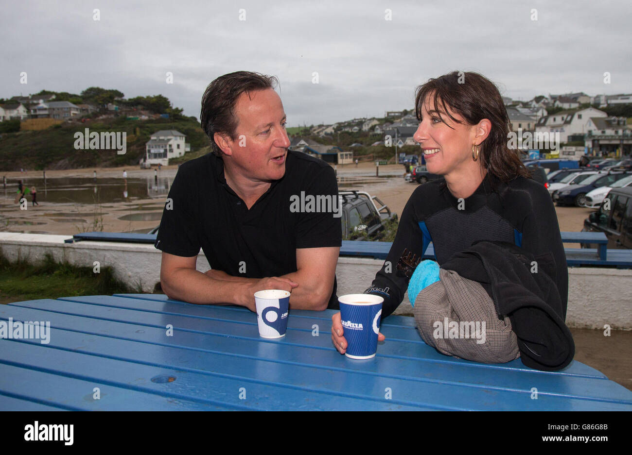 Prime Minister David Cameron and his wife Samantha have a coffee outside the Galleon Beach Cafe following an early morning swim in the sea during his holiday in the small seaside resort of Polzeath in Cornwall, England. Stock Photo