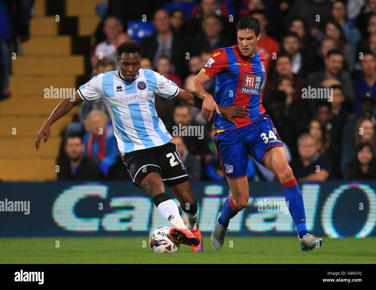 Shrewsbury's Jean-Louis Akpa Akpro, (left) battle for the ball with Crystal Palace's Martin Kelly, (right) during the Capital One Cup, second round match at Selhurst Park, London. Stock Photo