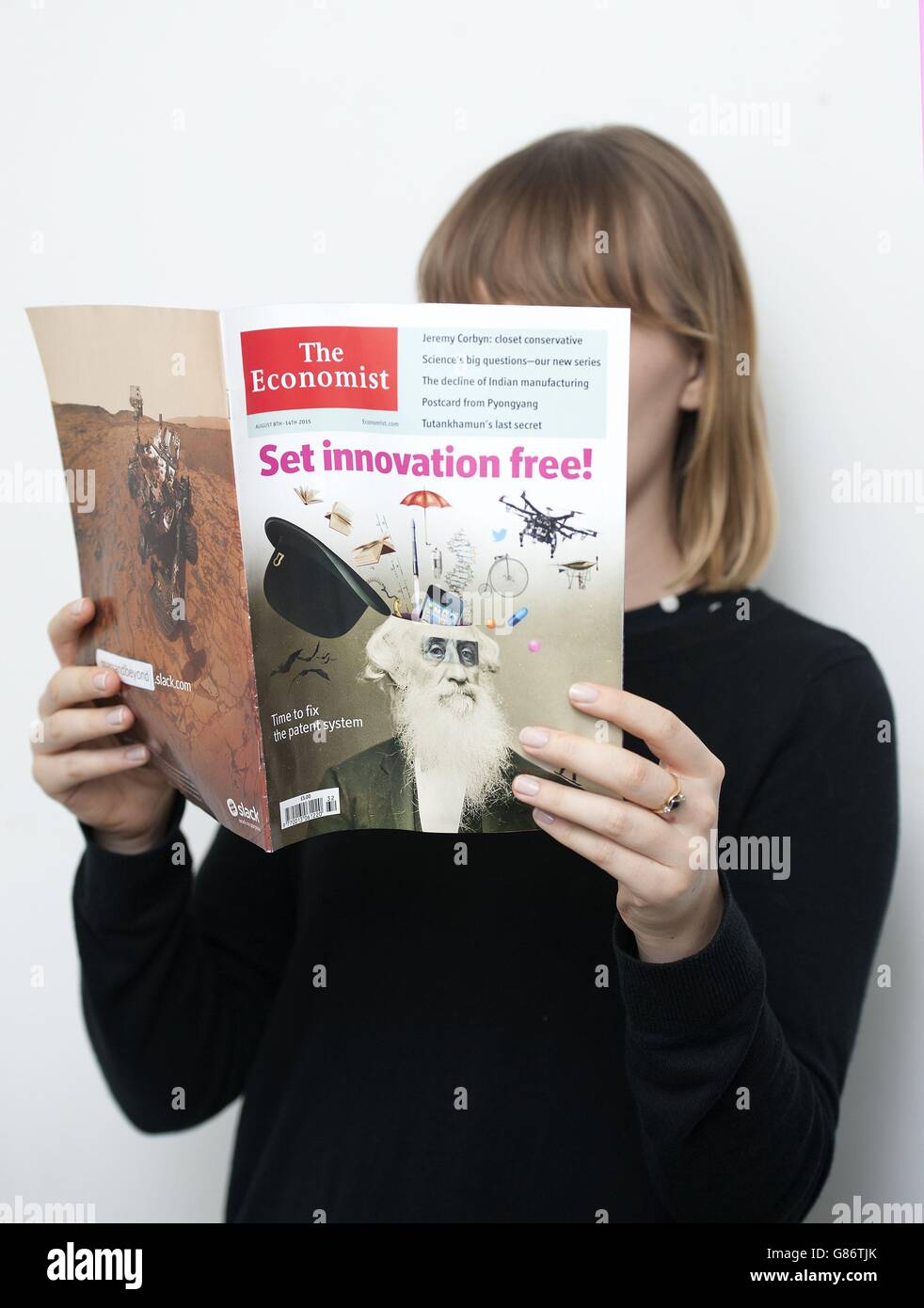 A woman reads a copy of The Economist magazine. Publishing group Pearson has agreed to sell its 50% stake in the Economist Group in a &Acirc;£469 million deal which will make Italy's Exor, controlled by the Agnelli dynasty, its biggest shareholder. Stock Photo