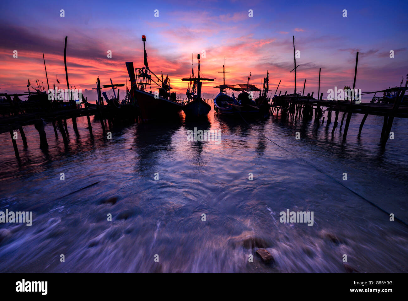 Fishing boats moored along jetty, Thailand Stock Photo