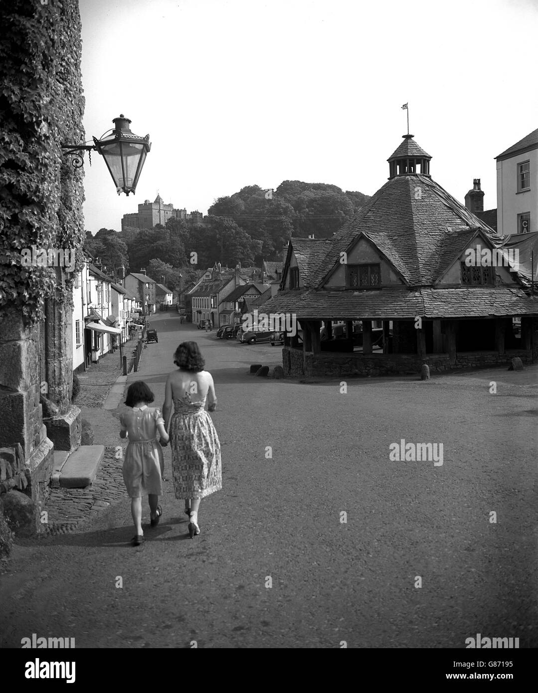 The main street in Dunster, Somerset, which features an ancient Yarn Market, built in 1609. In the background can be seen part of Dunster Castle, home of Geoffrey Luttrell. Stock Photo