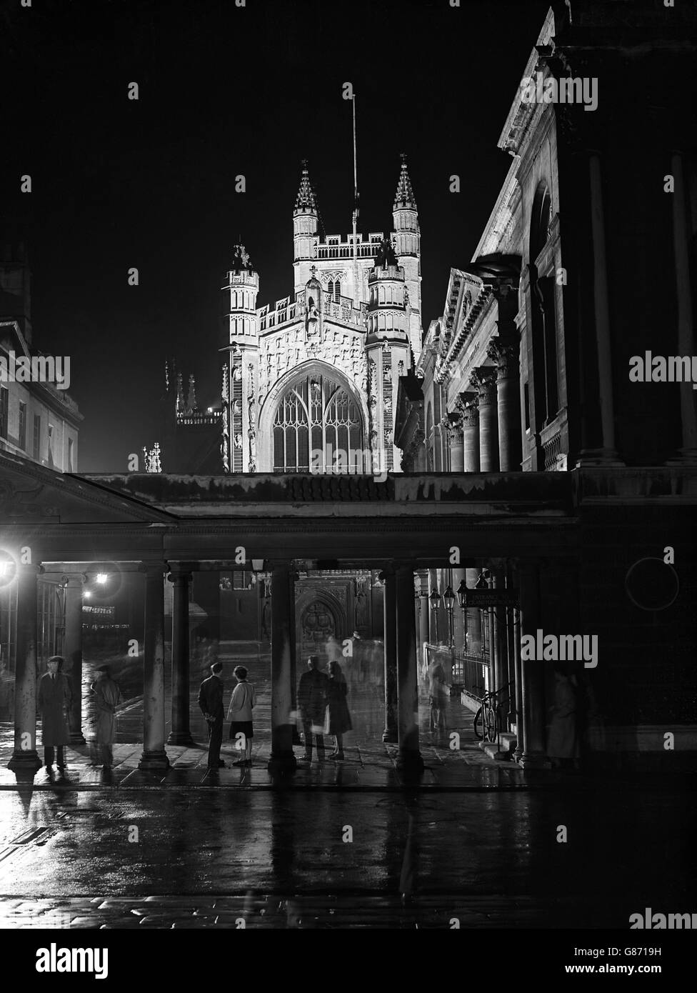 The west front of Bath Abbey, which is floodlit to celebrate the Bath Assembly. The famous Pump Room is at the right. Stock Photo
