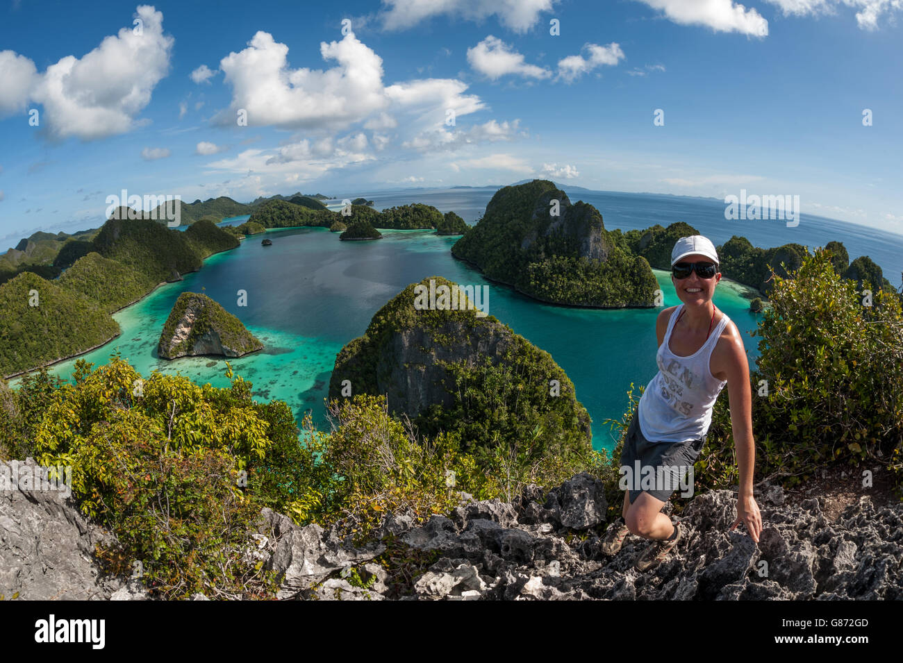 Woman standing on cliff, Raja Ampat Islands, West Papua, Indonesia Stock Photo