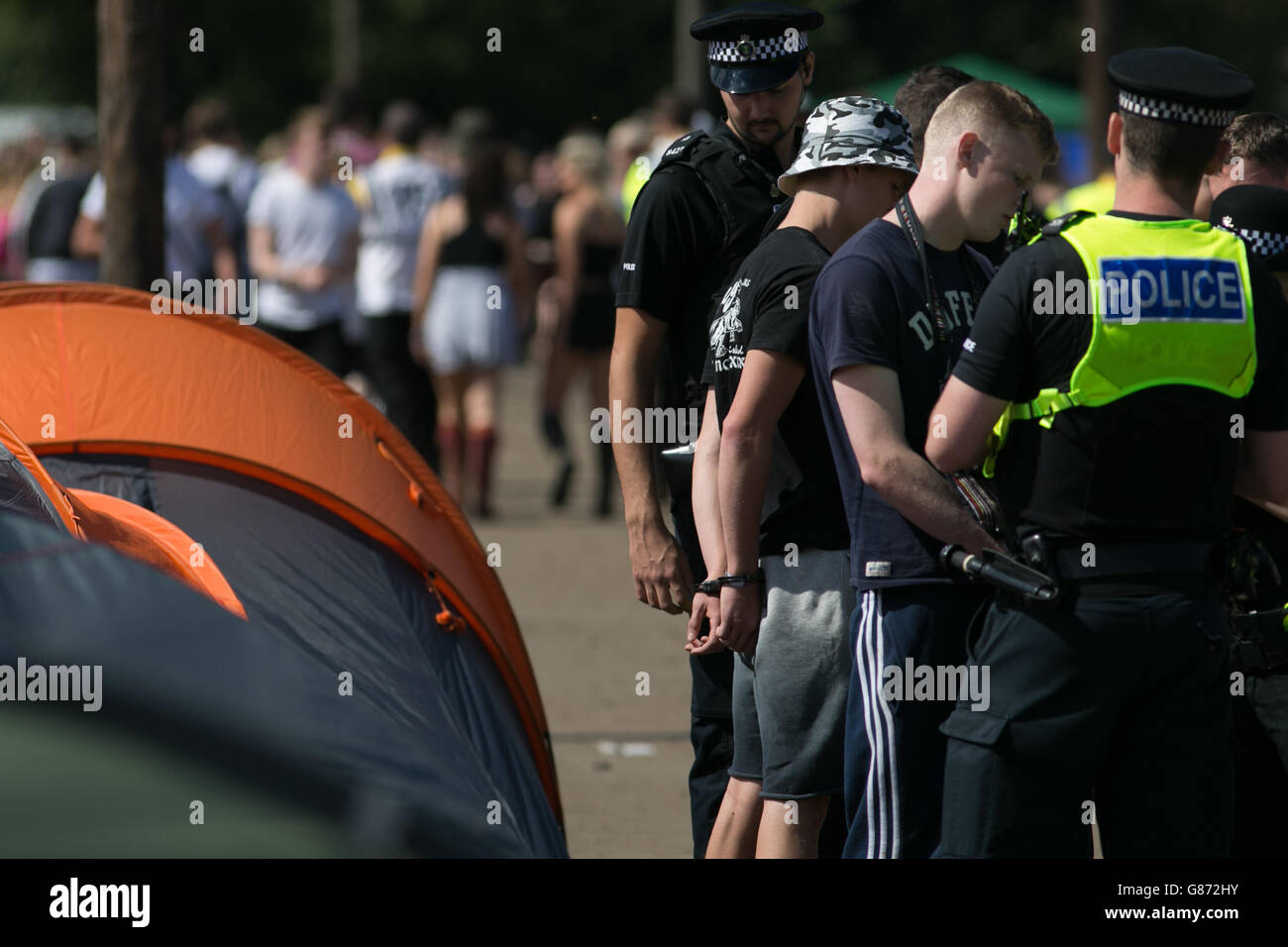 Police officers detain a couple of men on the first day of the Reading Festival in Berkshire. Stock Photo