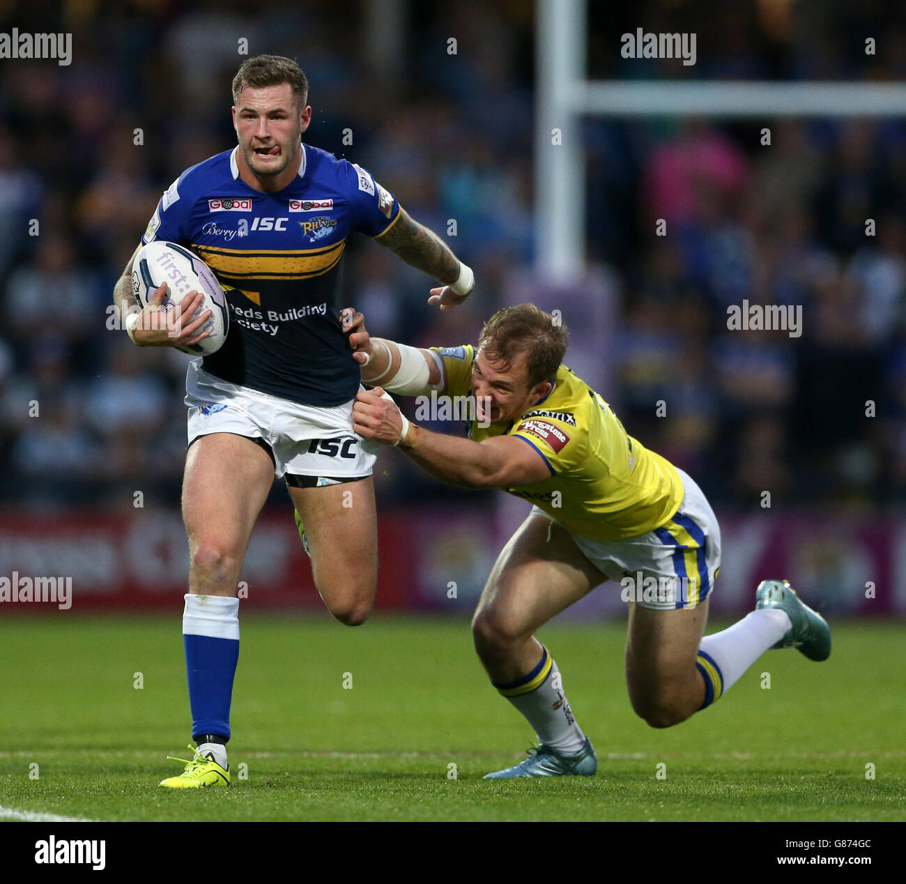 Leeds Rhino's Zak Hardaker (left) breaks away from Warrington Wolves' George King before scoring a try during the First Utility Super League, Super 8s match at Headingley Carnegie, Leeds. Stock Photo