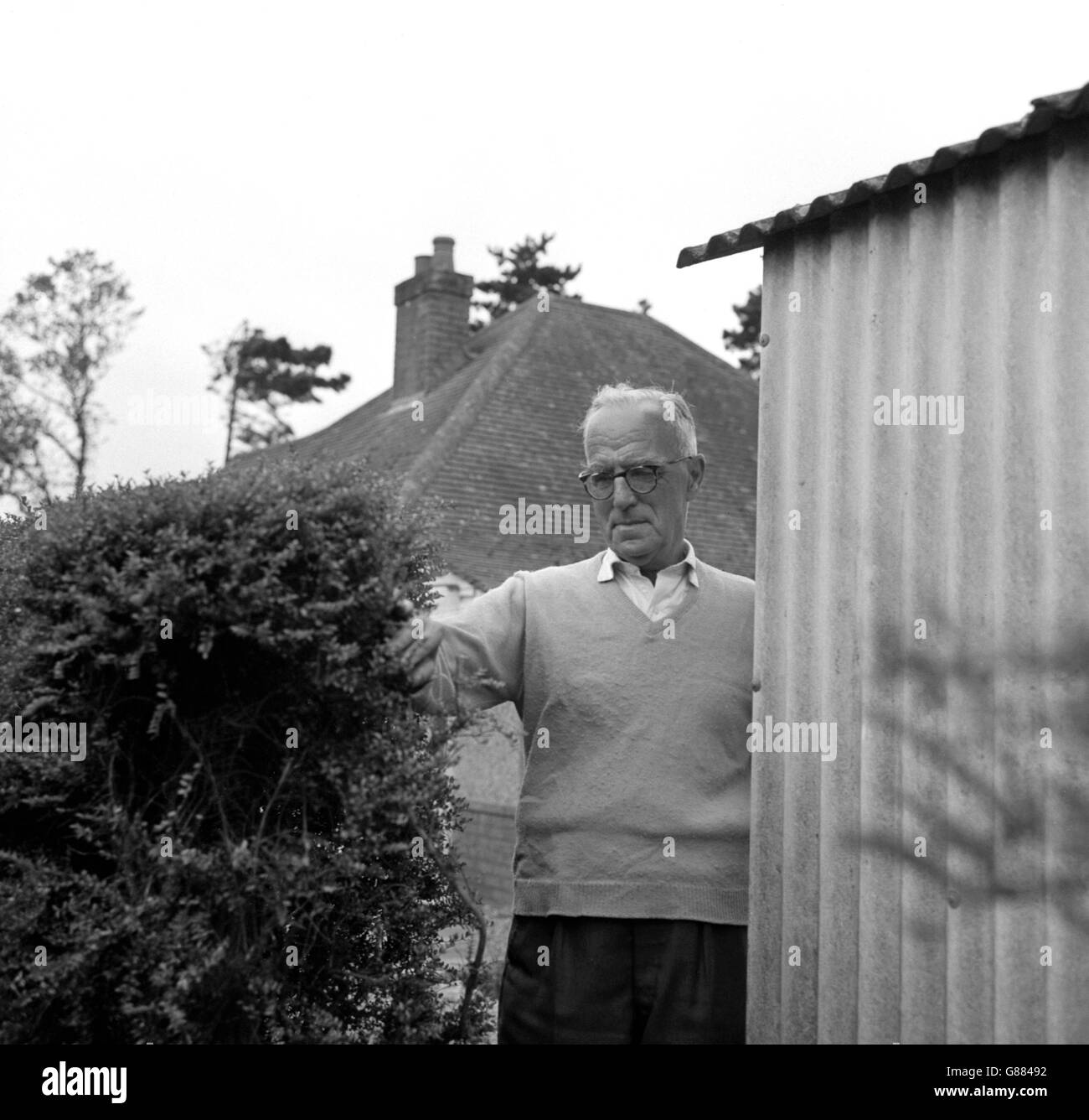 William Hamble, a retired Bank manager, photographed by the gap in his hedge through which the escaped Parkhurst prisoners pushed past him when they escaped from their escort, near Bishops Waltham, Hampshire. Stock Photo