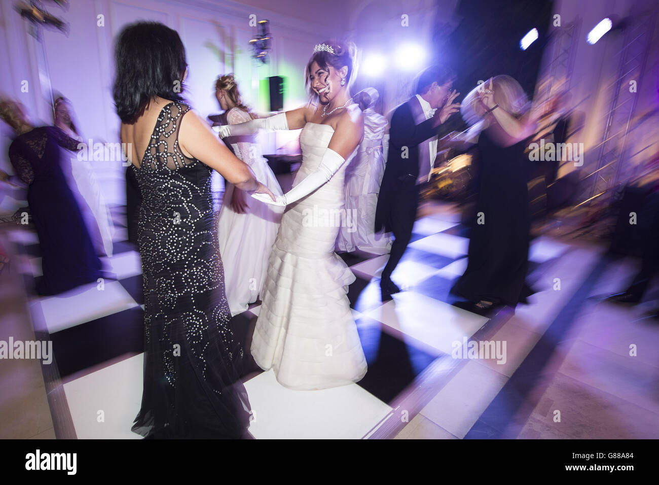 Debutantes dancing at the Queen Charlotte's Ball, in Kensington Palace, London. The Ball is the culmination of the debutante season, which traditionally introduced the daughters of British nobility into society. Stock Photo