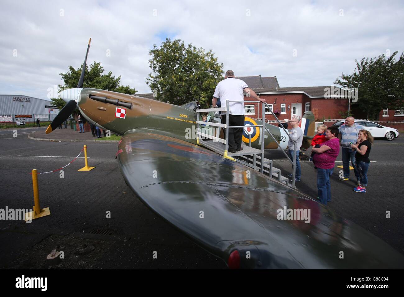 A replica of a Spitfire on display during an unveiling of an anti-racism mural entitled Band as of Brothers, on a peace wall off the Shankil Road Belfast on the 75th anniversary of the Battle of Britain to mark the valiant efforts of Polish airmen, who were stationed in Northern Ireland. Stock Photo