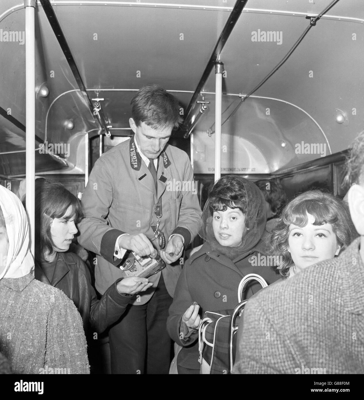 Roger Tyrell of Essex is pictured issuing tickets on a vehicle operated by Upminster and District Super Coaches on London Transport's former 169B route between Barkingside and the Hainault Factory Estate, Essex. The LT Board today withdrew many of its services as a result of the busmen's overtime ban. Stock Photo