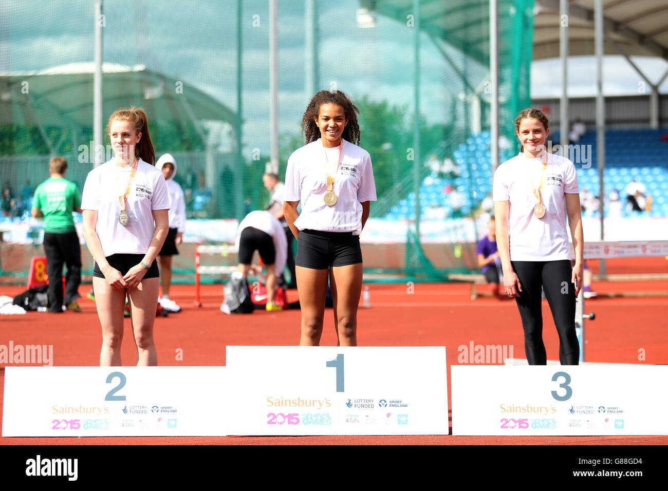 (l-r) England South West's Anna Croft, England North West's Chloe Esegbona and England Midlands' Danel Jansen Van Rensburg receive their girls 300m hurdles medals during the medal ceremony at the Sainsbury's 2015 School Games at the Manchester Regional Arena. Stock Photo