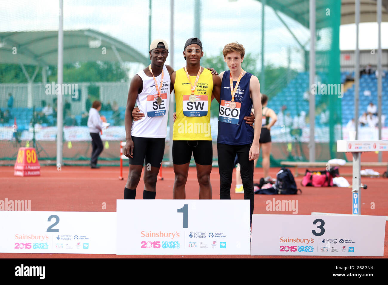 (l-r) England South East's Joe Winn, England South West's Patrick Sylla and Scotland's Alessandro Schenini receive their boys long jump medals during the medal ceremony at the Sainsbury's 2015 School Games at the Manchester Regional Arena. Stock Photo