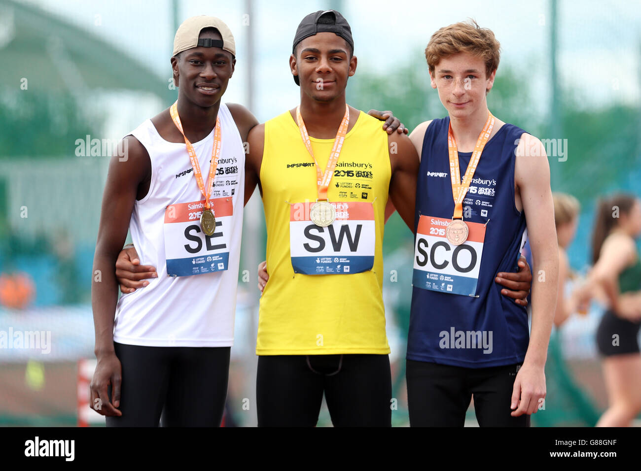 (l-r) England South East's Joe Winn, England South West's Patrick Sylla and Scotland's Alessandro Schenini receive their boys long jump medals during the medal ceremony at the Sainsbury's 2015 School Games at the Manchester Regional Arena. Stock Photo