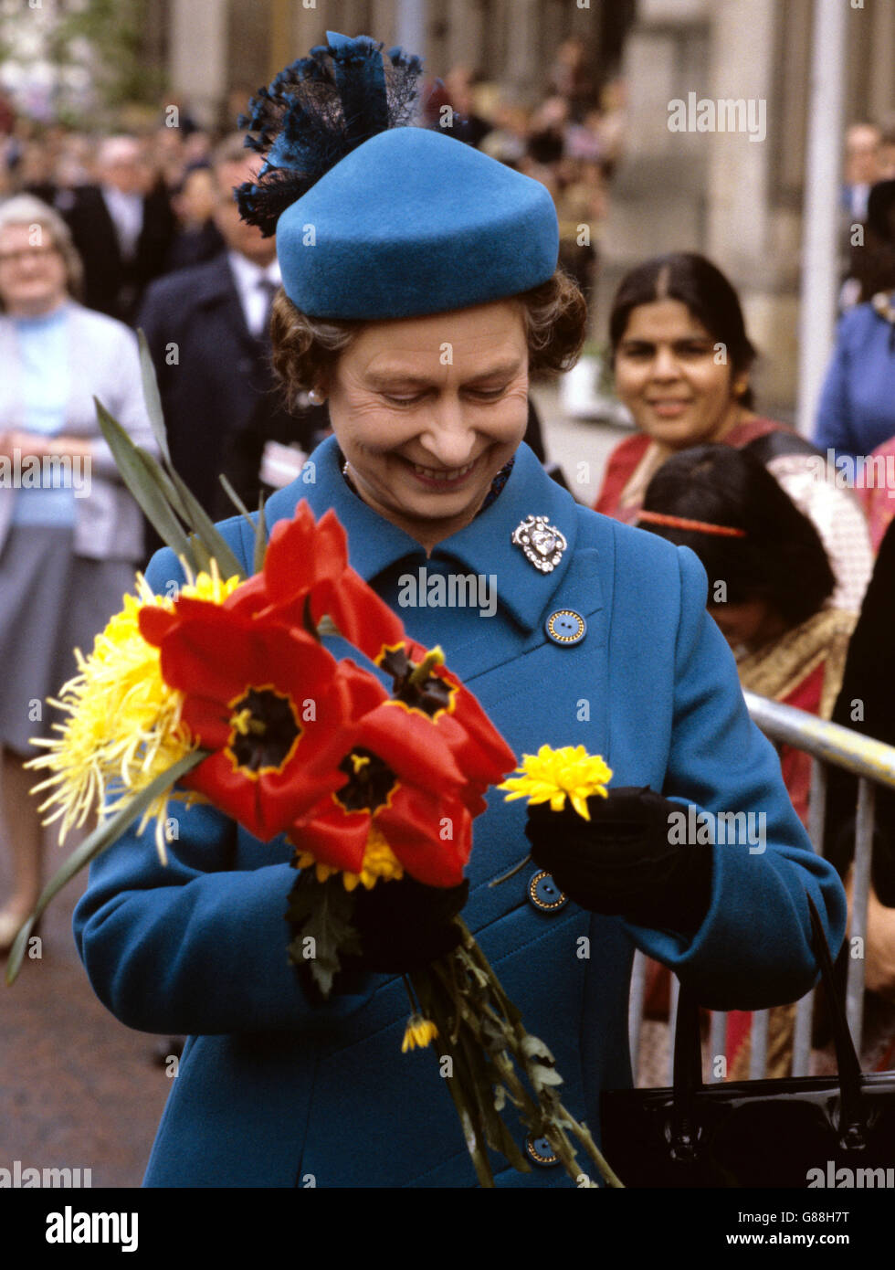 Queen Elizabeth II holding a bouquet during a walkabout in Manchester's Albert Square after she visited the TV 'Coronation Street' set. Stock Photo