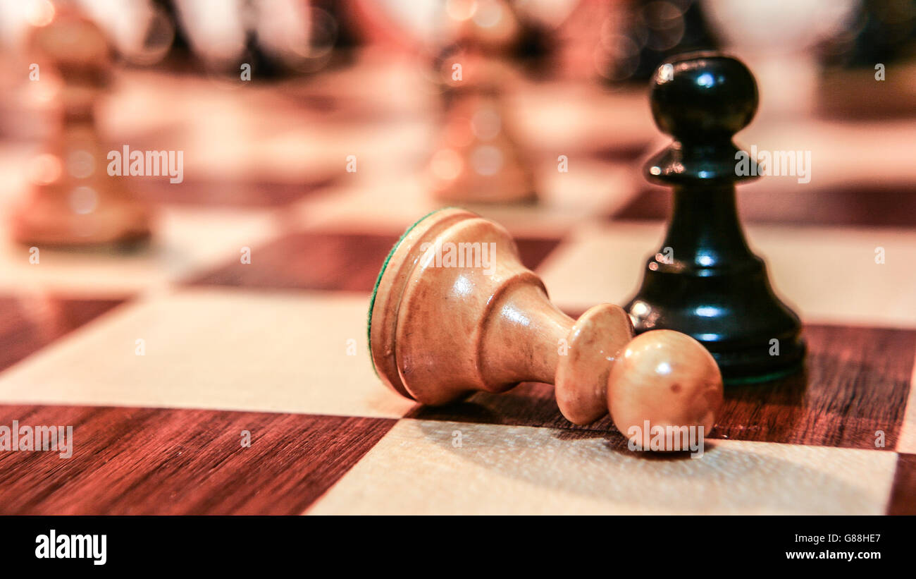 Fallen chess pawn on chess board Stock Photo