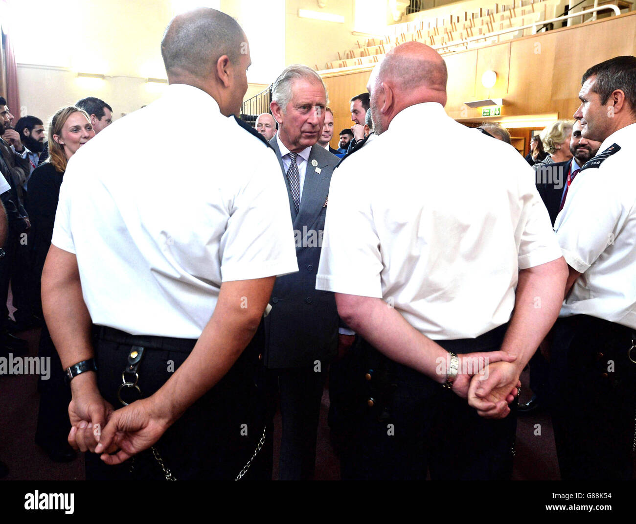 The Prince of Wales (centre) speaks to prison guards involved in his
