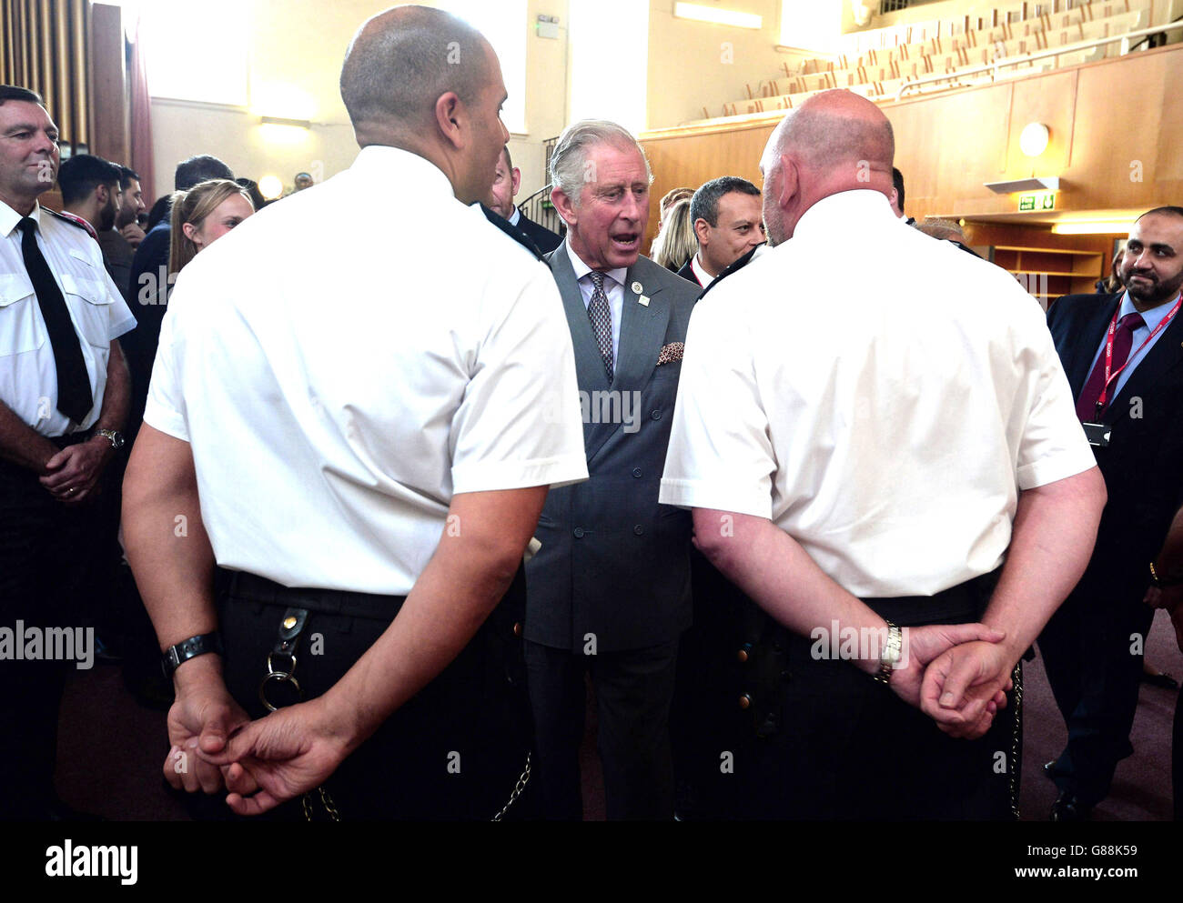 The Prince of Wales (centre) speaks to prison guards involved in his
