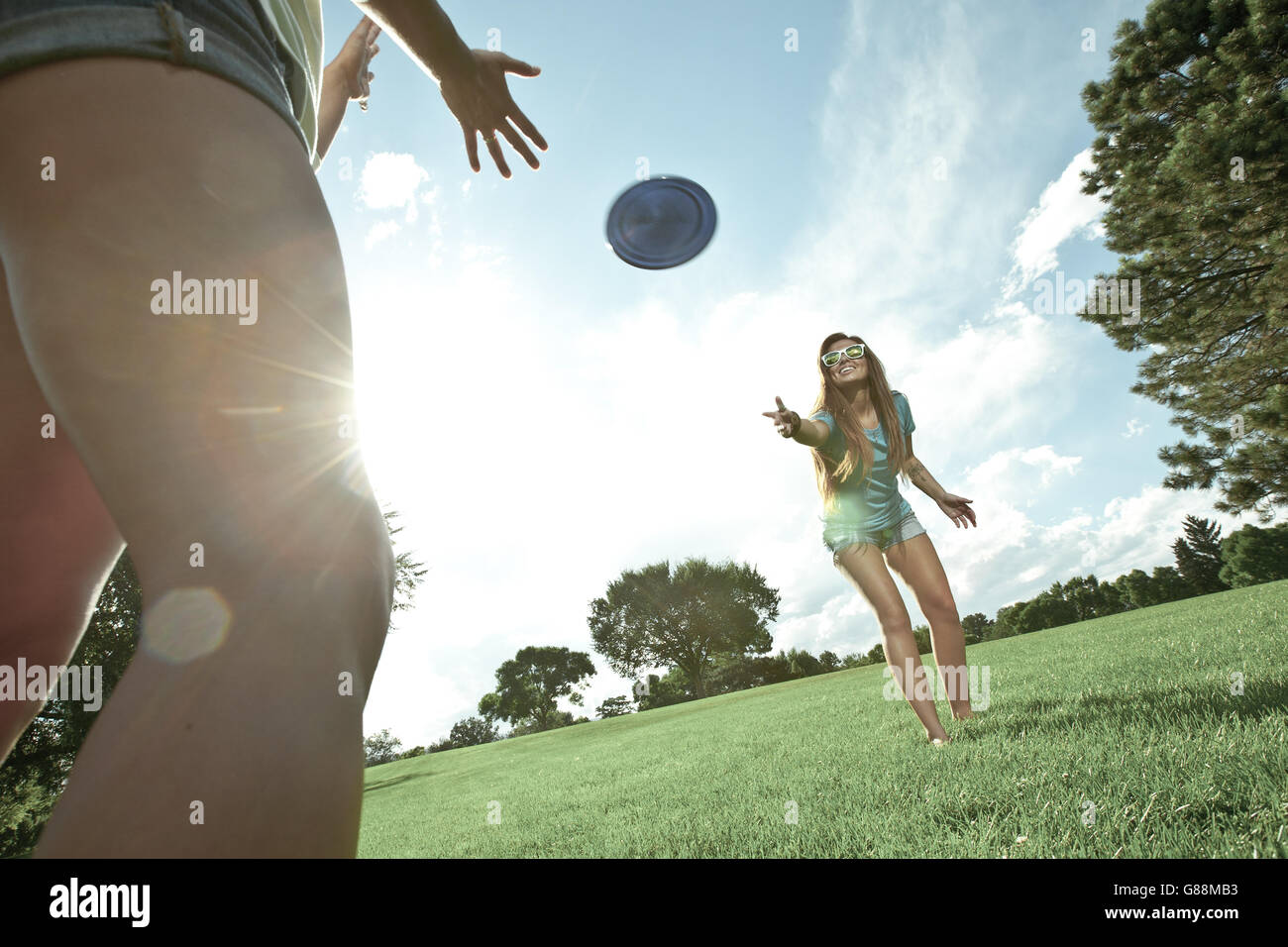 Two women playing game of Frisbee in park Stock Photo