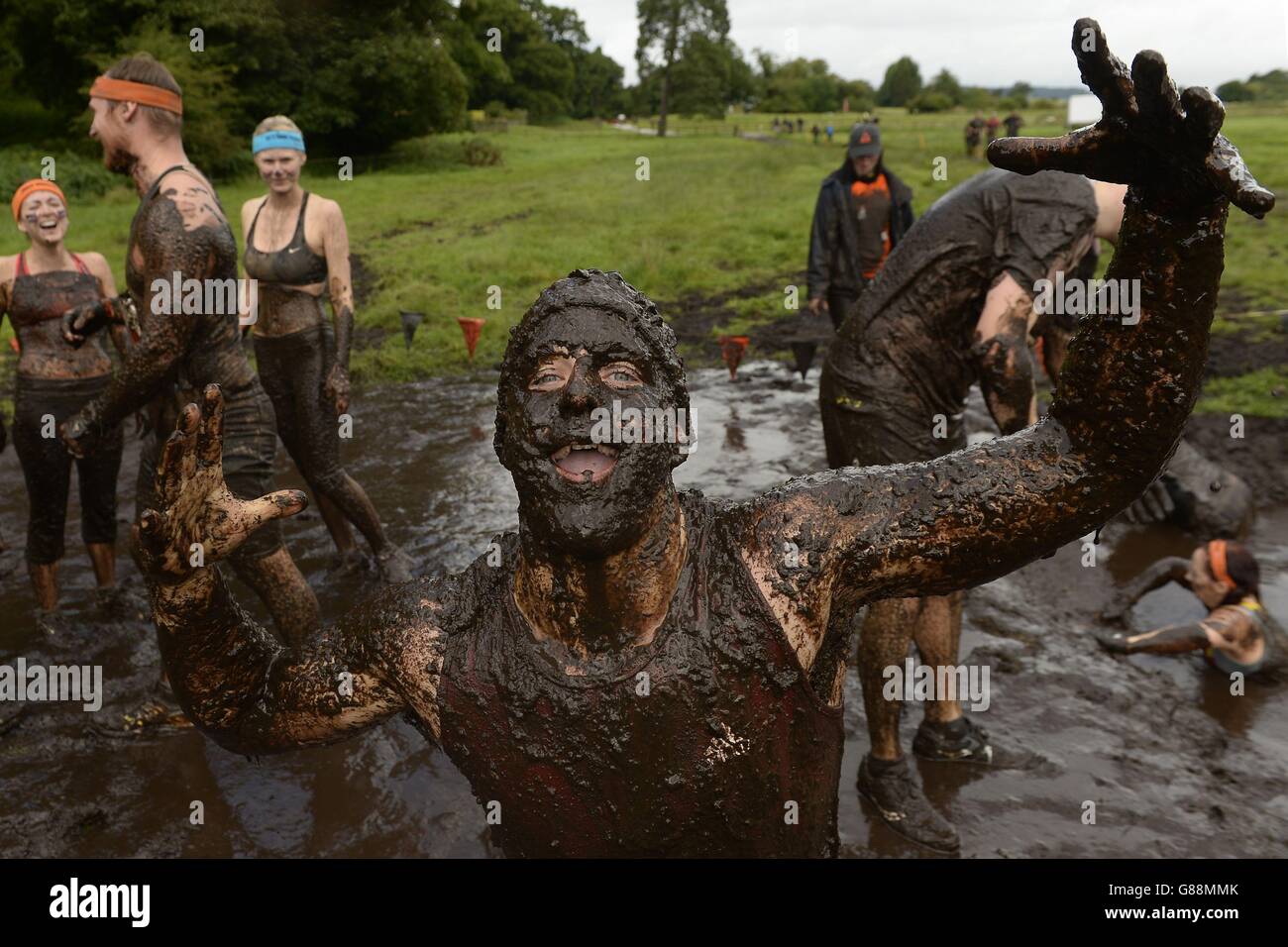 Participants covered in mud during Tough Mudder North West at the Cholmondeley Estate in Malpas, Cheshire. Stock Photo