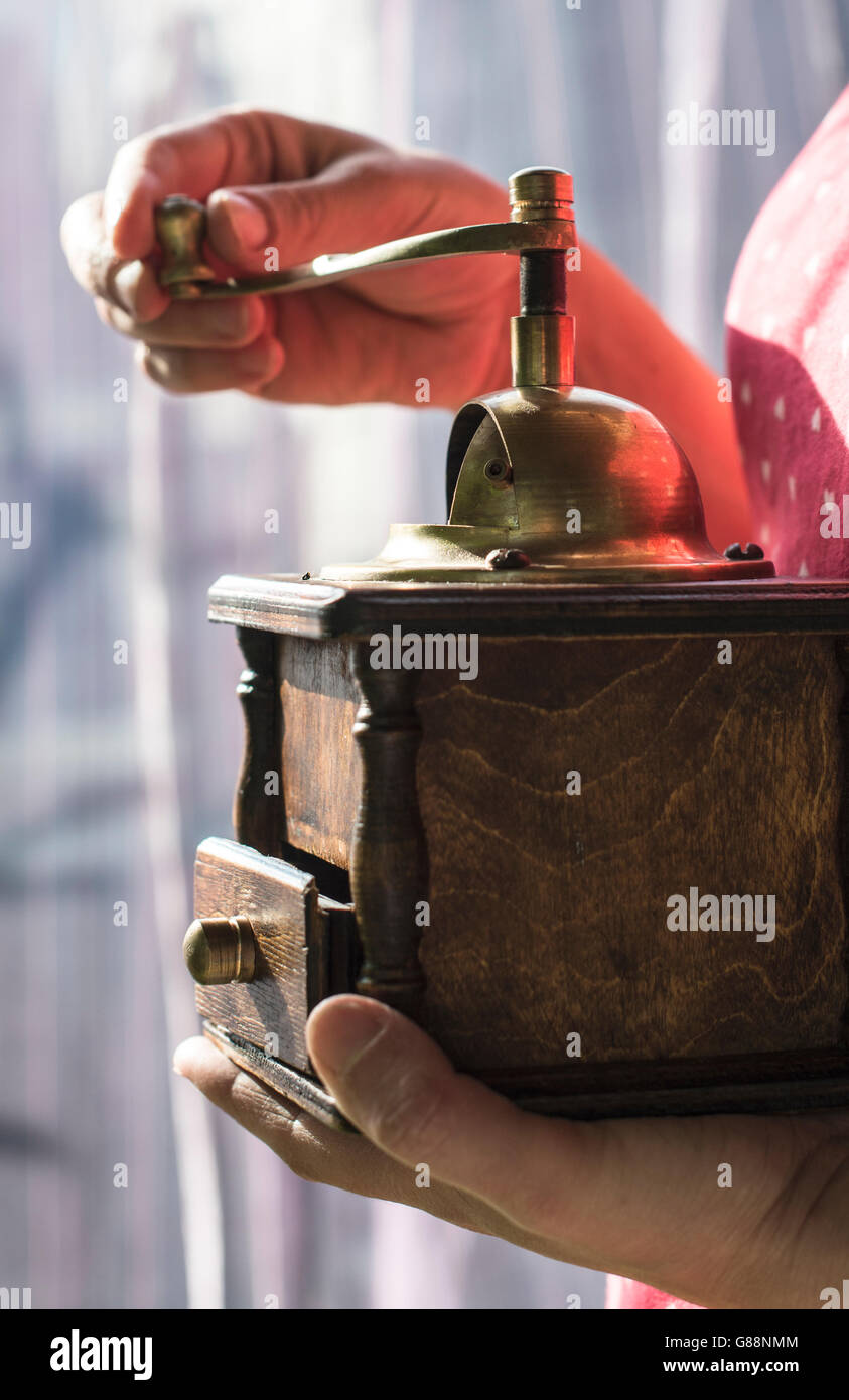 Woman grinding coffee with vintage coffee grinder Stock Photo