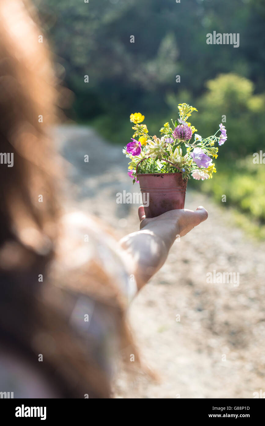 Woman holding a flower pot with wildflowers Stock Photo