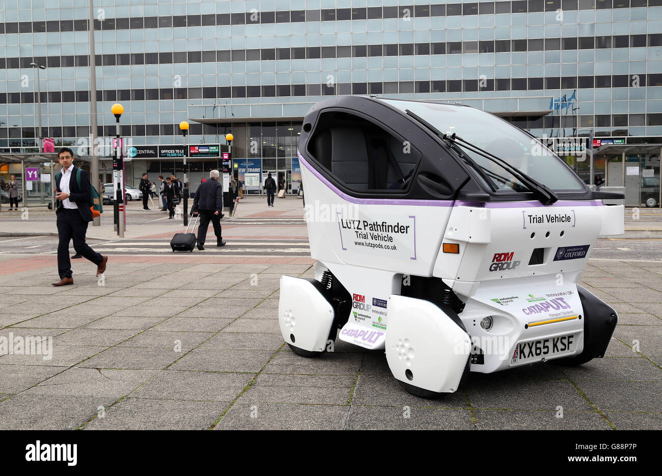 The UK's Transport Systems Catapult unveils its first LUTZ Pathfinder pod vehicle to commuters outside Milton Keynes Central train station, as part of a project trialling self-driving technology in pedestrianised areas. Stock Photo